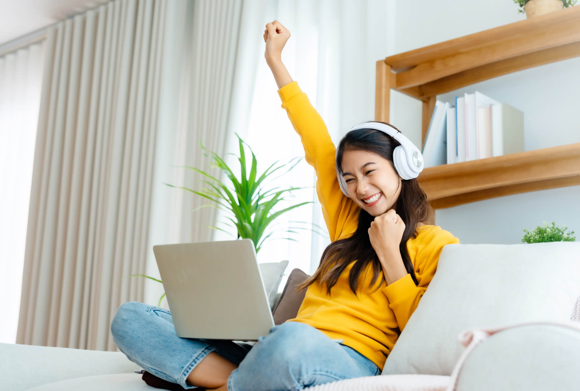 A woman with headphones and laptop