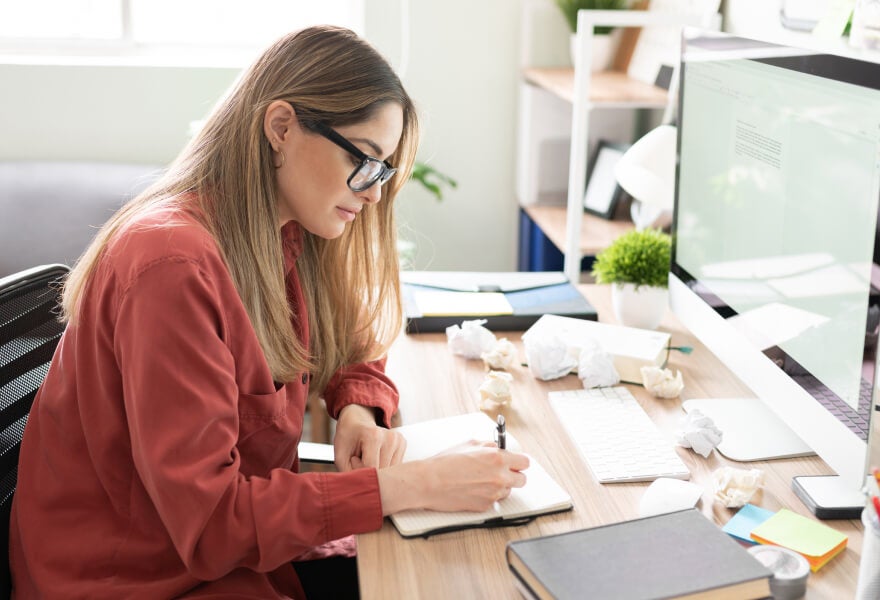 A woman writing on a notebook