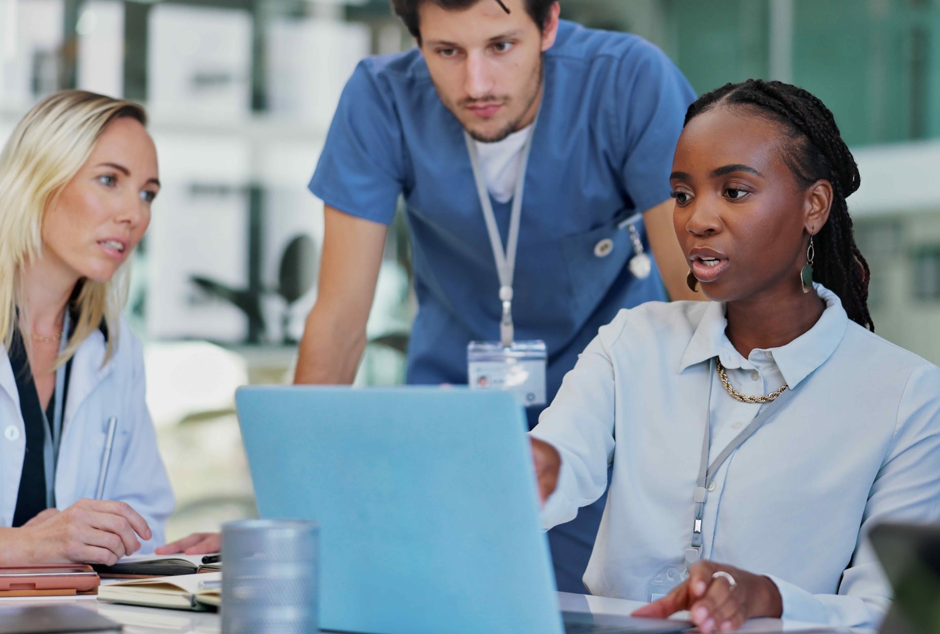 A team of medical professionals collaborating together around a laptop.