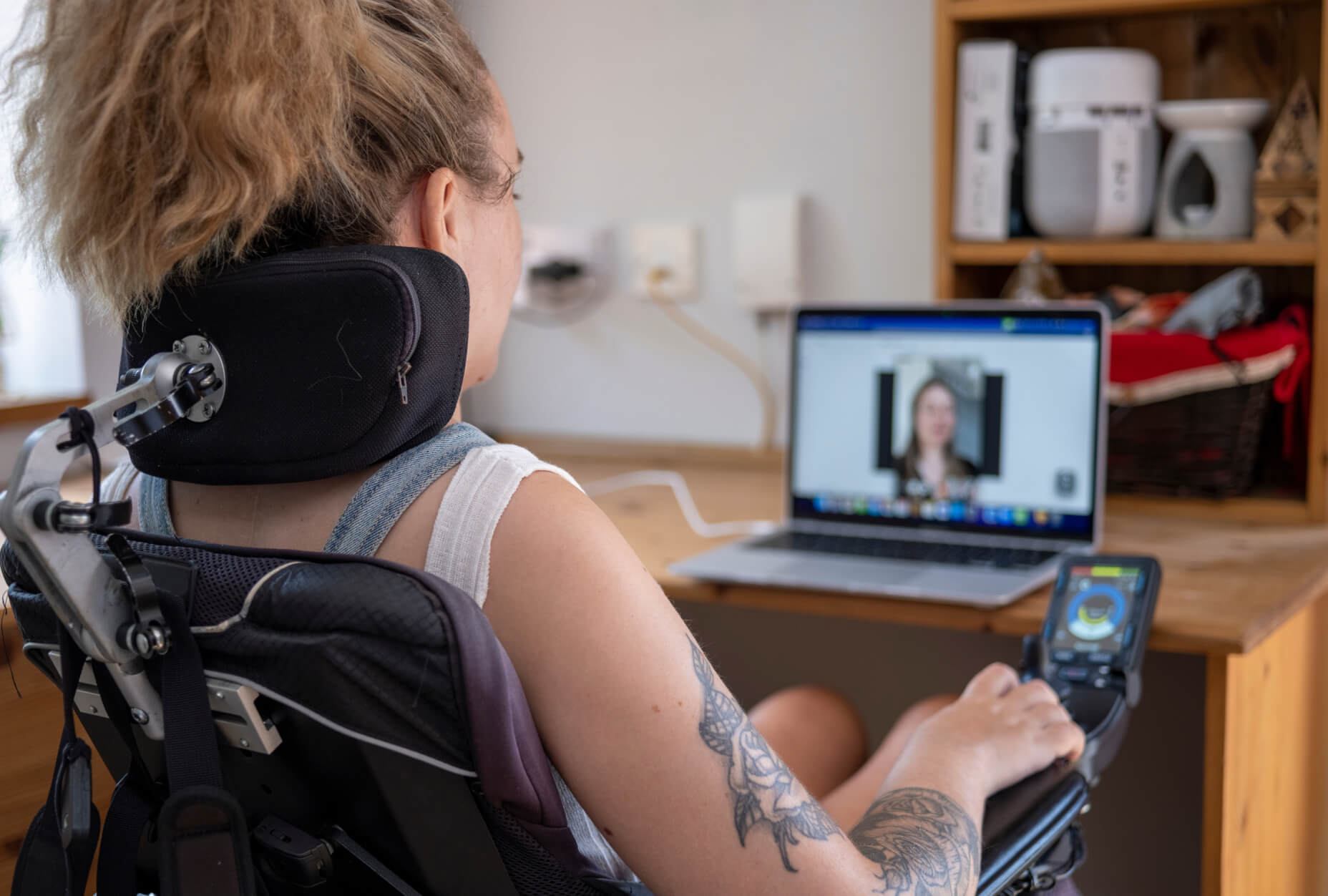 A woman sitting in a wheelchair and using a screen reader