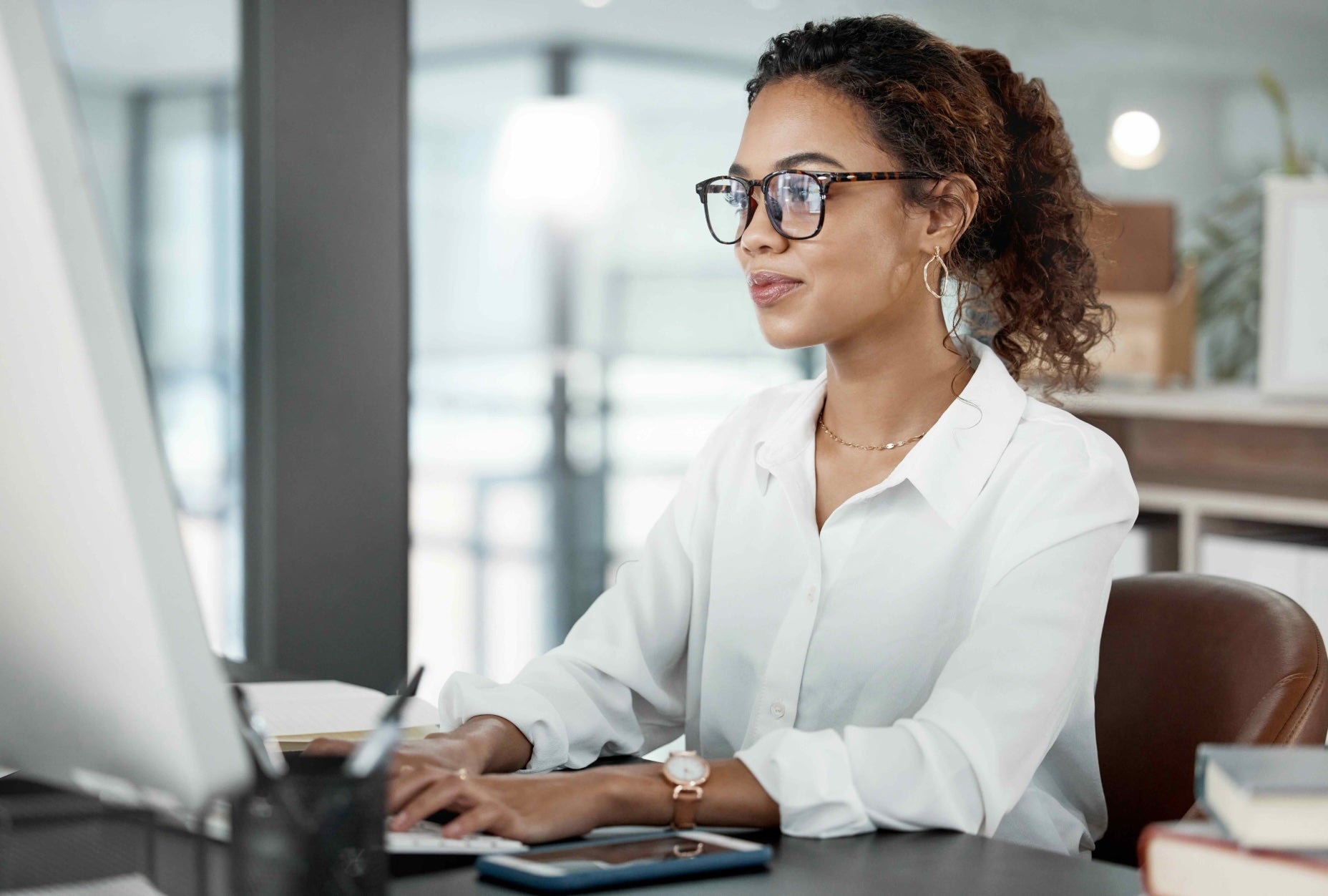 A woman sitting at a desk using a computer