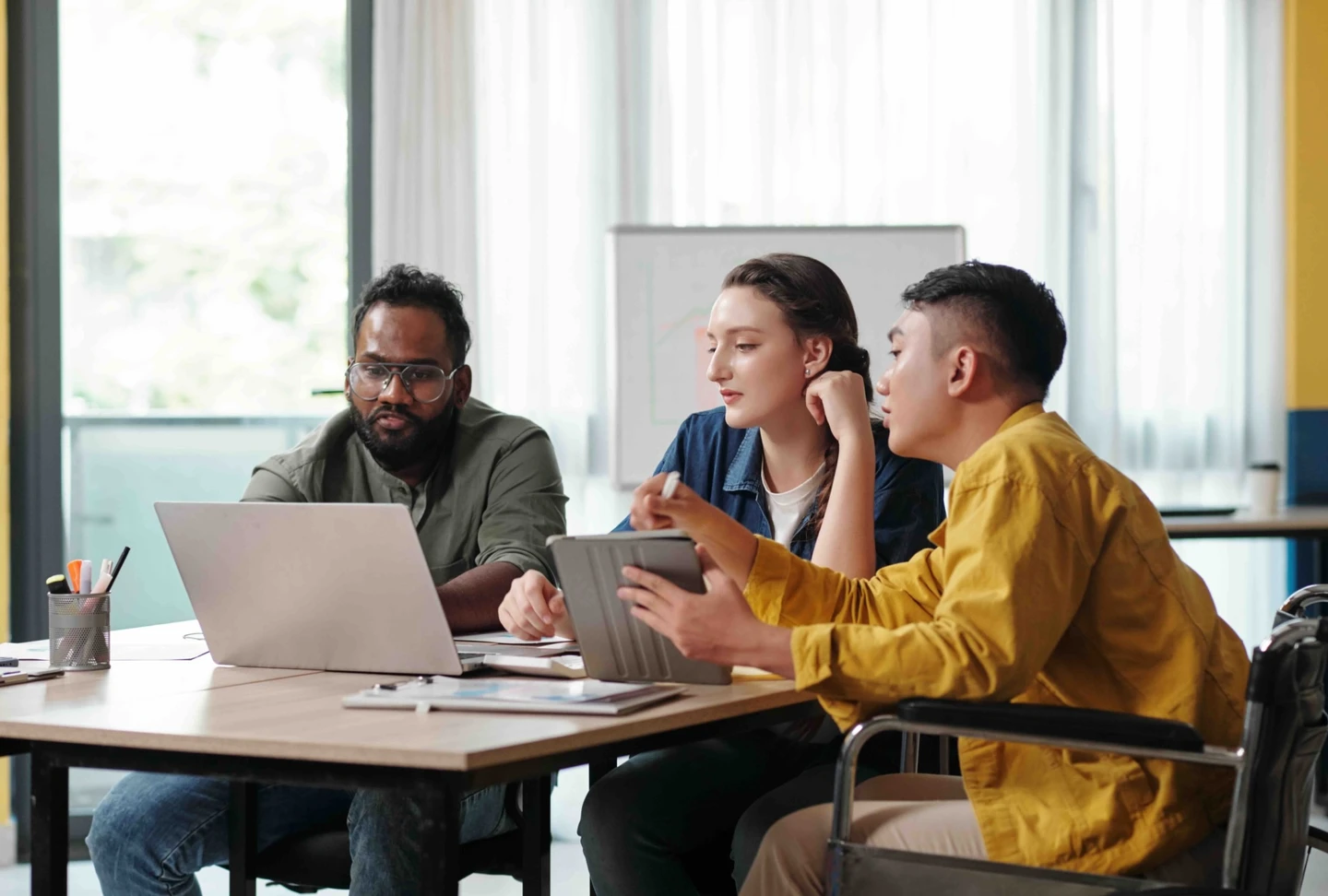 Team sitting around a table looking at a laptop.