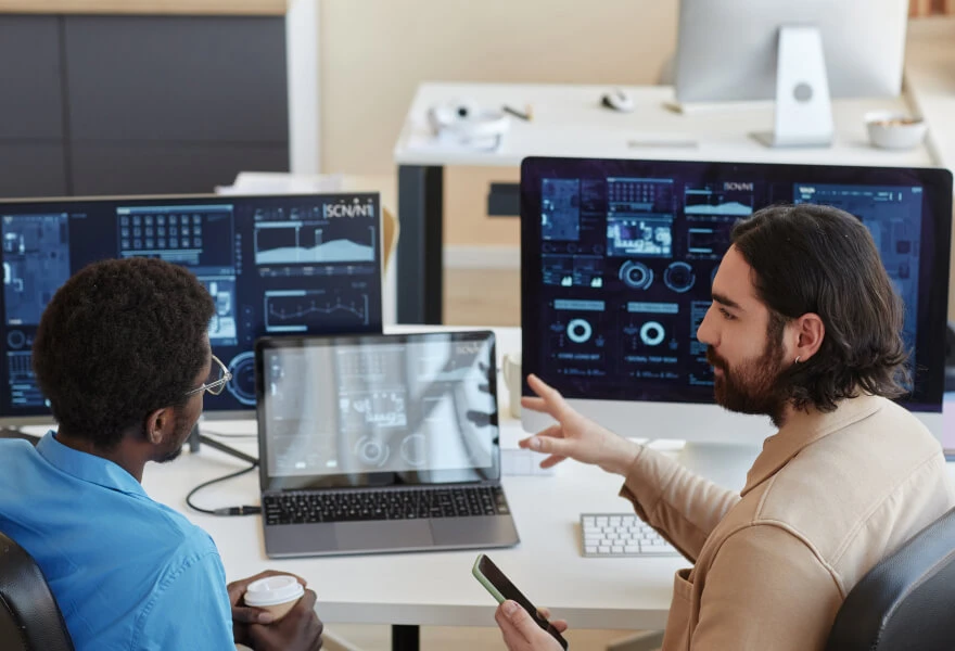 A group of men sitting at a desk with computers