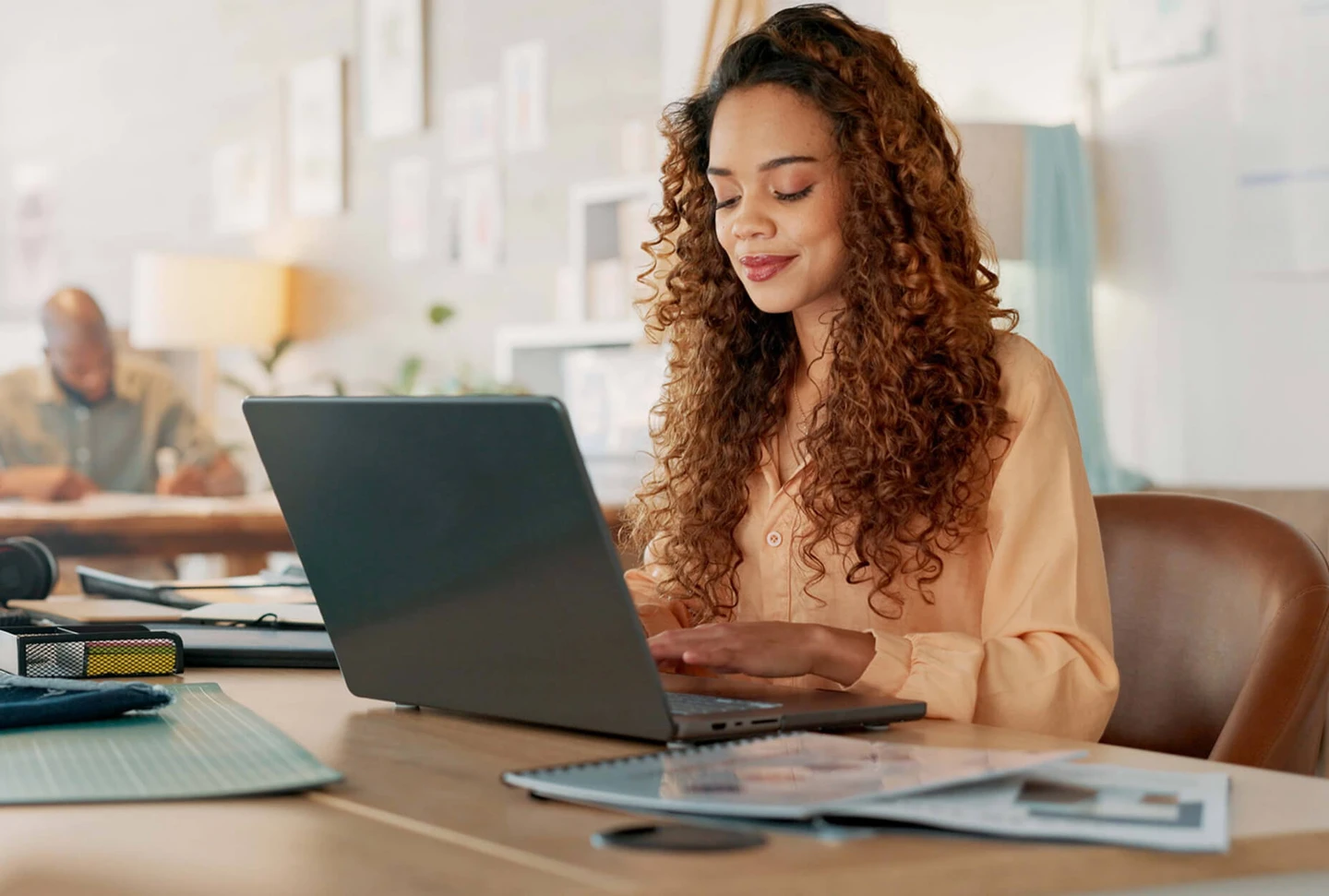 A woman sitting at a desk with a laptop