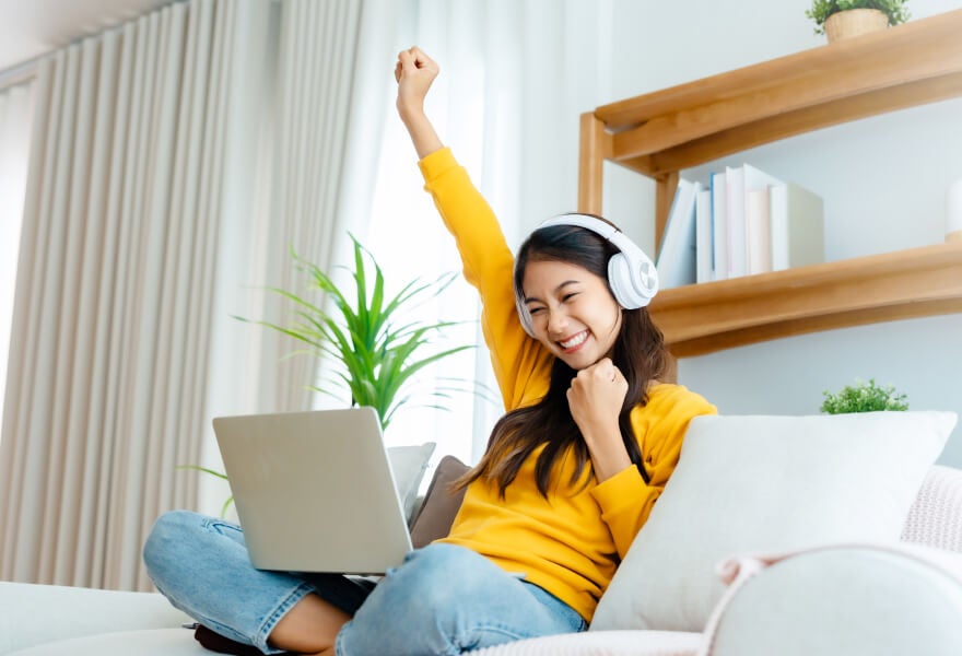 A woman with headphones and laptop