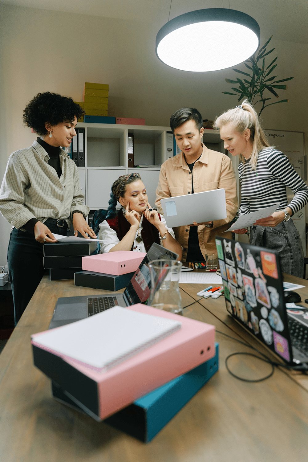 Office where four young people are working on a project