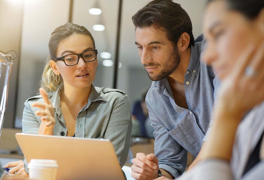 A group of people looking at a laptop
