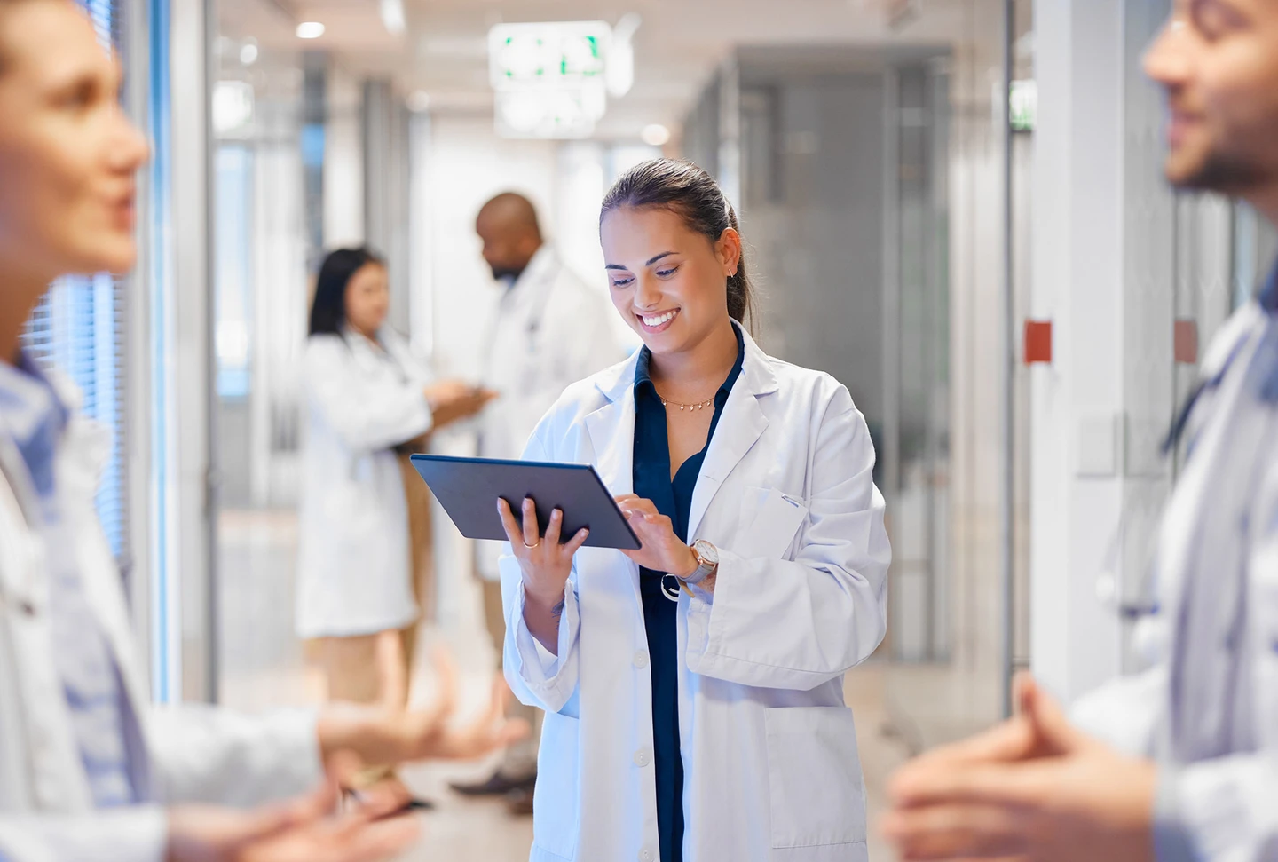 A woman in a white coat using a tablet