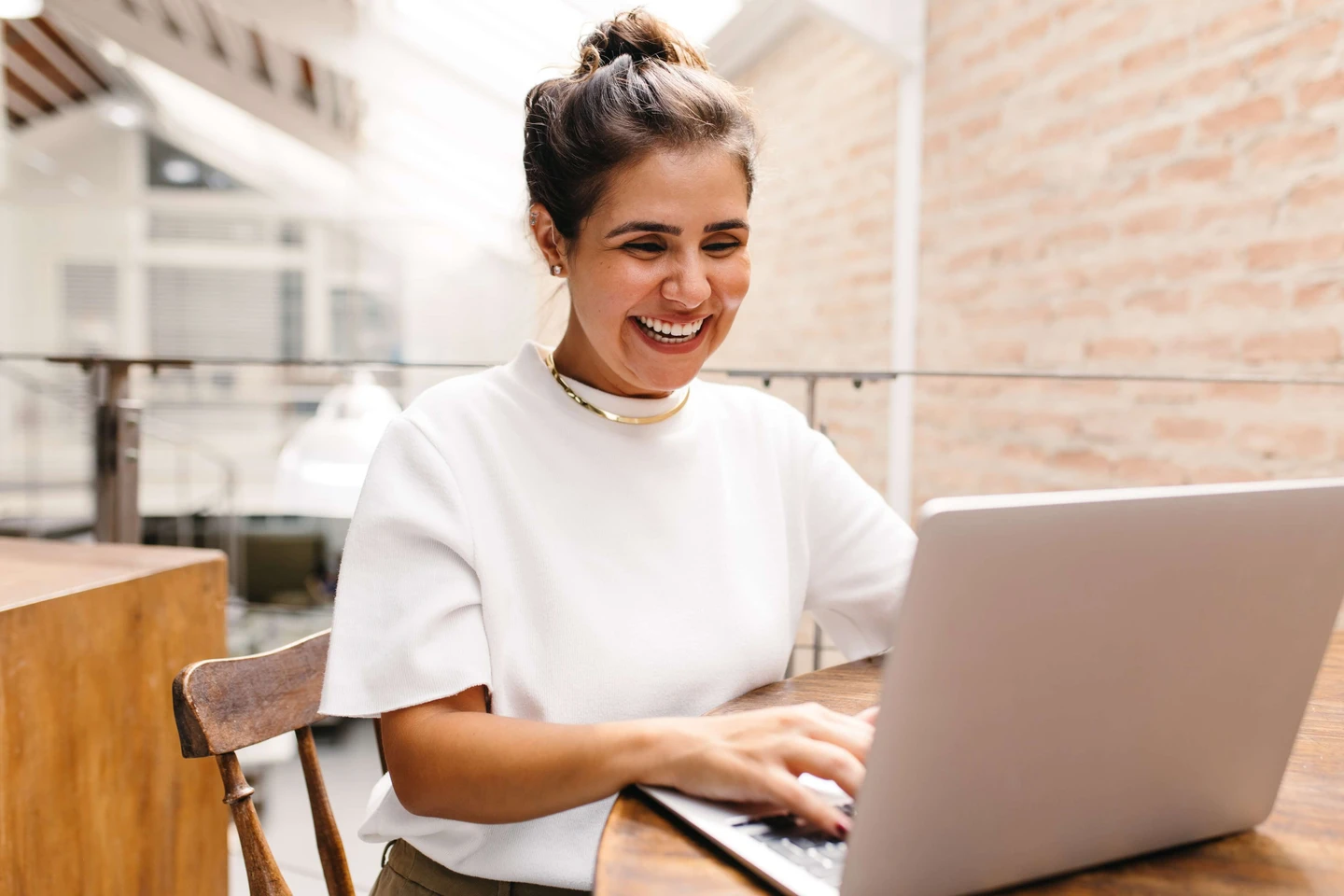 A woman smiling at a laptop