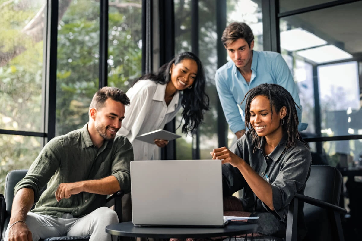 A group of people looking at a laptop