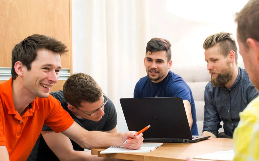A group of Kontent.ai employees looking at a laptop