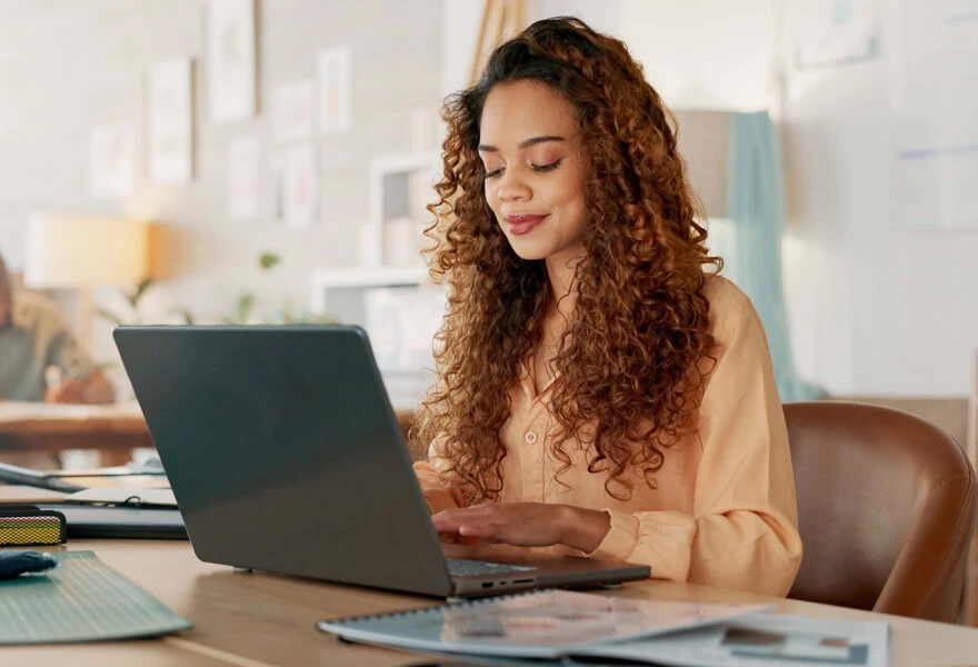 A woman sitting at a desk with a laptop