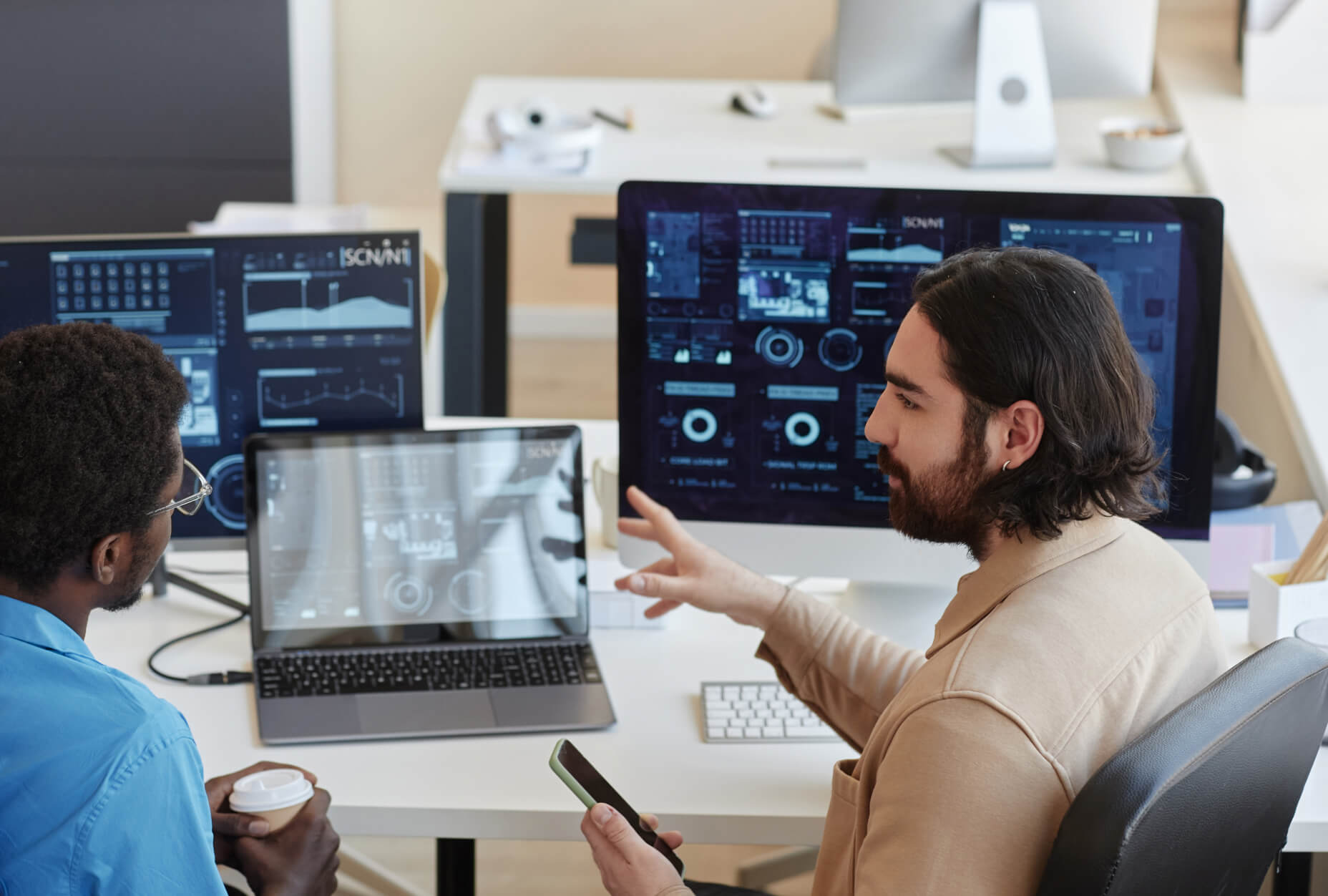 A group of men sitting at a desk with computers